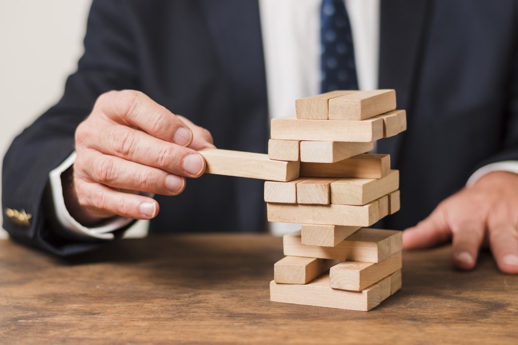 A man playing with jenga blocks. Image for the blog - Risk Projection in Software Engineering